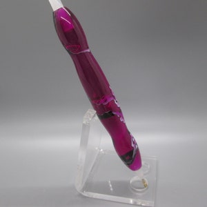 May include: A purple and white swirl pen with a black accent, displayed on a clear acrylic stand.