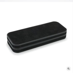 Pu&ograve; includere: Una gomma per lavagna rettangolare e nera. La gomma ha una superficie morbida, simile al feltro, per pulire le lavagne. I bordi sono arrotondati e la gomma &egrave; realizzata in un materiale denso.