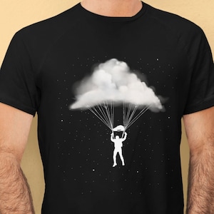 May include: A black t-shirt with a white graphic of a person skydiving with a cloud as a parachute.