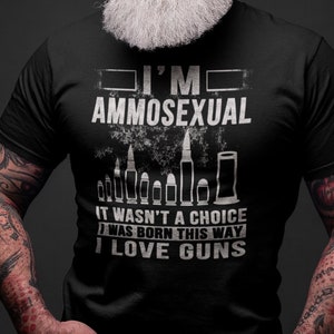 May include: A black t-shirt with a white graphic that says "I'm Ammosexual. It wasn't a choice, I was born this way. I love guns." The graphic also includes a row of bullet casings.