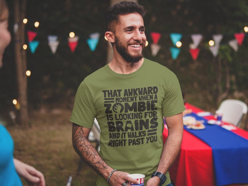 May include: A green t-shirt with a black graphic print that reads "That awkward moment when a zombie is looking for brains and it walks right past you".