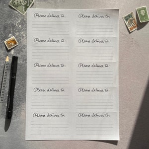 May include: A white sheet of paper with five lines on each side, with the text "Please deliver to:" written at the top of each side.