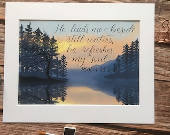 May include: A watercolor painting of a lake surrounded by trees at sunset. The text "He leads me beside still waters, he refreshes my soul. PSALM 23:2-3" is written in cursive script.