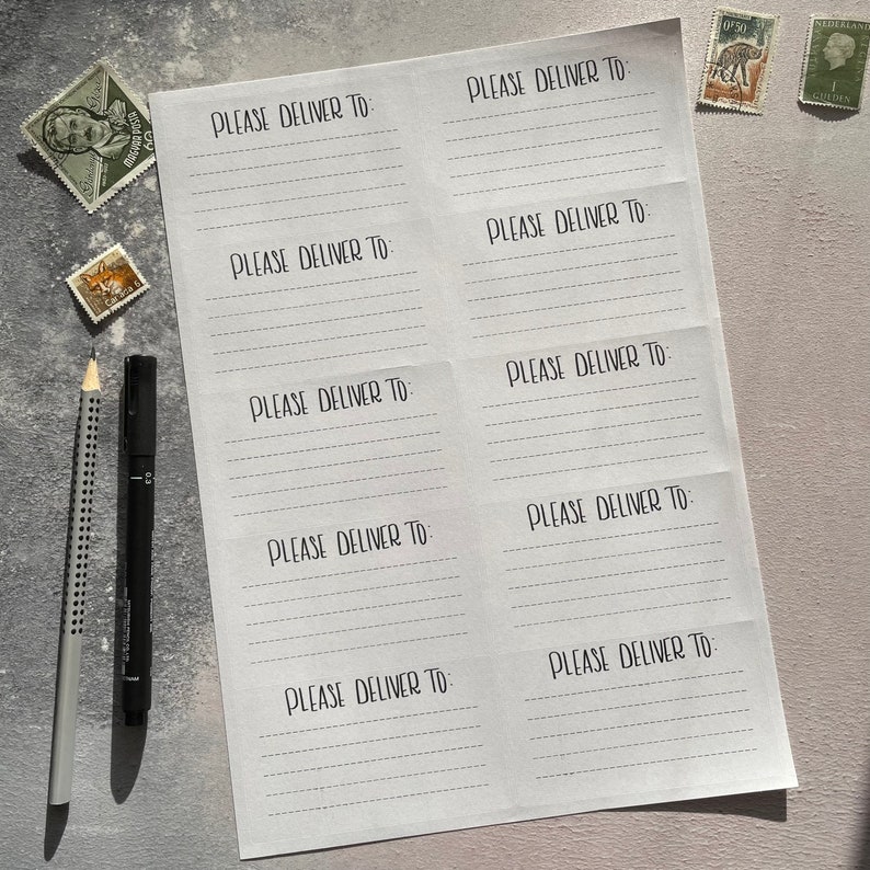 May include: A white sheet of paper with the text "PLEASE DELIVER TO" repeated multiple times in a handwritten font. The paper is folded in half and has a lined pattern.