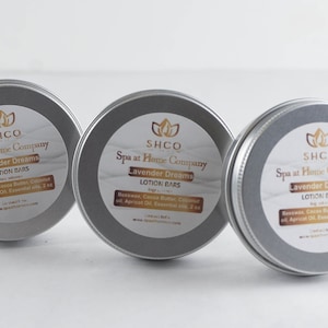 May include: Three silver tins with labels that read "SHCO Spa at Home Company Lavender Dreams Lotion Bars" with ingredients listed below.