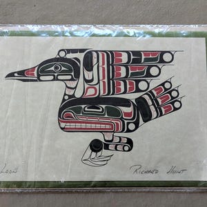 May include: A print of a stylized bird, featuring black, red, and white geometric designs. The word "Loon" is printed in the lower left corner, and the artist's name, "Richard Hunt," is printed in the lower right corner. The print is on a light green background.