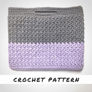 May include: A crochet bag with a gray top and a lavender bottom. The bag has a single handle and a crocheted pattern.