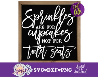 May include: A black sign with white text that reads "Sprinkles are for cupcakes not for toilet seats". The sign is framed in wood and has a cut file label in the top right corner.