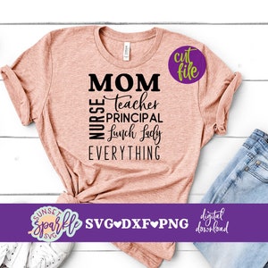 May include: A pink t-shirt with the text "MOM NURSE TEACHER PRINCIPAL LUNCH LADY EVERYTHING" in black. The text is in a vertical column with the word "MOM" at the top. The shirt is on a white wooden surface with a pair of white sneakers and a pair of blue jeans in the background.