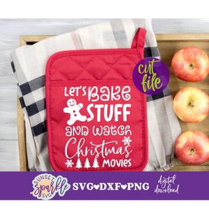 Może przedstawiać: Czerwona rękawica do garnków z białym tekstem, który brzmi "Let's bake stuff and watch Christmas movies". Wzór piernika jest włączony. Rękawica do garnków znajduje się na kratkowanej tkaninie z jabłkami w tle.
