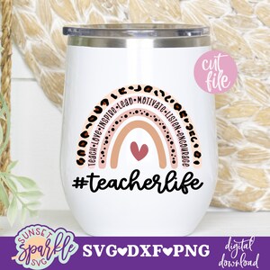 May include: White stainless steel tumbler with a rainbow design and the text "#teacherlife". The rainbow is made up of pink, orange, and yellow stripes with brown leopard print spots around the edges. The text is in black.