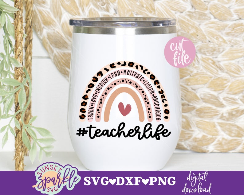 May include: White stainless steel tumbler with a rainbow design and the text "#teacherlife". The rainbow is made up of pink, orange, and yellow stripes with brown leopard print spots around the edges. The text is in black.