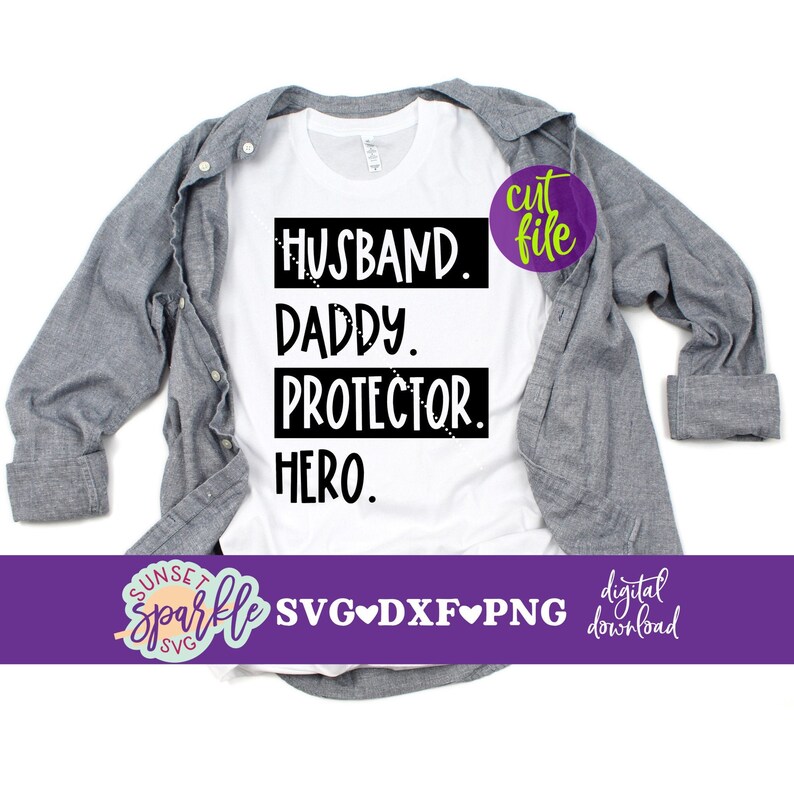 May include: A white t-shirt with black text that reads "Husband. Daddy. Protector. Hero." The shirt is folded and laid on a grey surface.