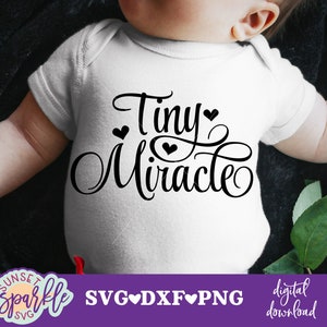 May include: White baby onesie with black text that reads "Tiny Miracle" with small hearts around the text.