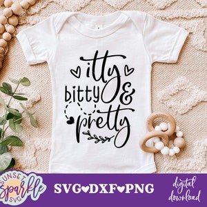 May include: White baby onesie with black text that reads "itty bitty & pretty" with hearts and a small branch design.