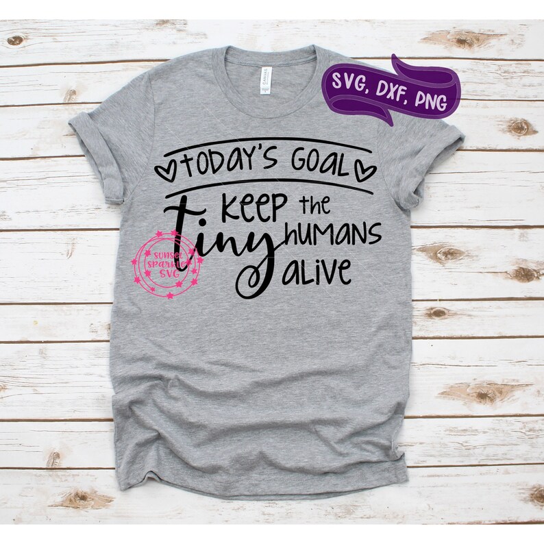 May include: Gray t-shirt with black text that reads "Today's Goal: Keep the Tiny Humans Alive".