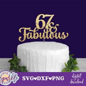 May include: Gold glitter cake topper with the text "67 & Fabulous" on a white cake.