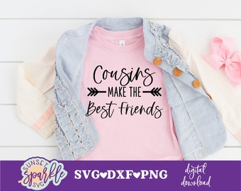 May include: Pink t-shirt with black text that reads "Cousins Make The Best Friends" with an arrow pointing to the right. The shirt is on a white surface with a denim jacket and a pink bow.