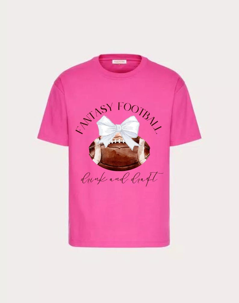 Op de afbeelding: Roze T-shirt met een witte strik op een voetbalafbeelding en de tekst "Fantasy Football drink and draft".