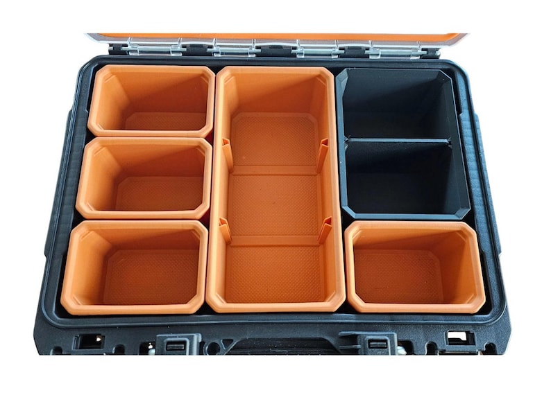 May include: An open black toolbox with orange plastic storage compartments. The compartments are arranged in a grid pattern with a larger compartment in the center.