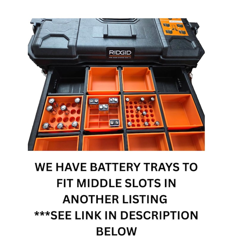 May include: Black RIDGID Pro Gear System tool box with orange battery trays. The trays are filled with various batteries. The text on the image reads: "WE HAVE BATTERY TRAYS TO FIT MIDDLE SLOTS IN ANOTHER LISTING ***SEE LINK IN DESCRIPTION BELOW."