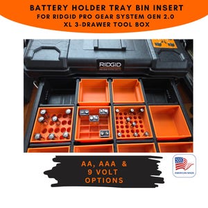 Pode incluir: Caixa de ferramentas preta com suportes de bateria laranja para pilhas AA, AAA e 9 volts. O texto na imagem diz "BATTERY HOLDER TRAY BIN INSERT FOR RIDGID PRO GEAR SYSTEM GEN 2.0 XL 3-DRAWER TOOL BOX." A imagem tamb&eacute;m inclui o texto "AA, AAA & 9 VOLT OPTIONS" e "AMERICAN MADE."