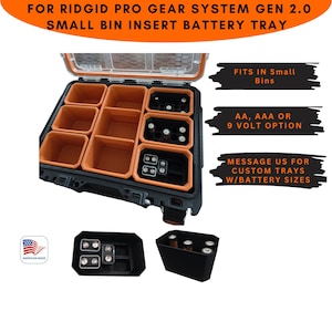 Puede incluir: Una bandeja para baterías negra y naranja para el contenedor pequeño del Ridgid Pro Gear System Gen 2.0. La bandeja tiene compartimentos para baterías AA, AAA o de 9 voltios. Texto: FOR RIDGID PRO GEAR SYSTEM GEN 2.0 SMALL BIN INSERT BATTERY TRAY.