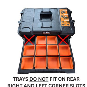 May include: Black RIDGID tool box with orange trays. The trays do not fit on the rear right and left corner slots. The tool box has a handle and latches for secure closure. The trays are orange and are designed for organizing tools.