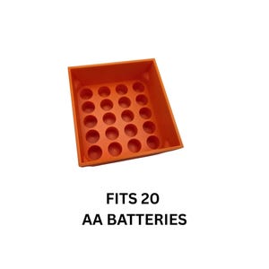 Pode incluir: Um organizador de pilhas de pl&aacute;stico laranja com 20 compartimentos circulares. O texto "FITS 20 AA BATTERIES" est&aacute; impresso abaixo. O organizador foi projetado para armazenar pilhas AA.