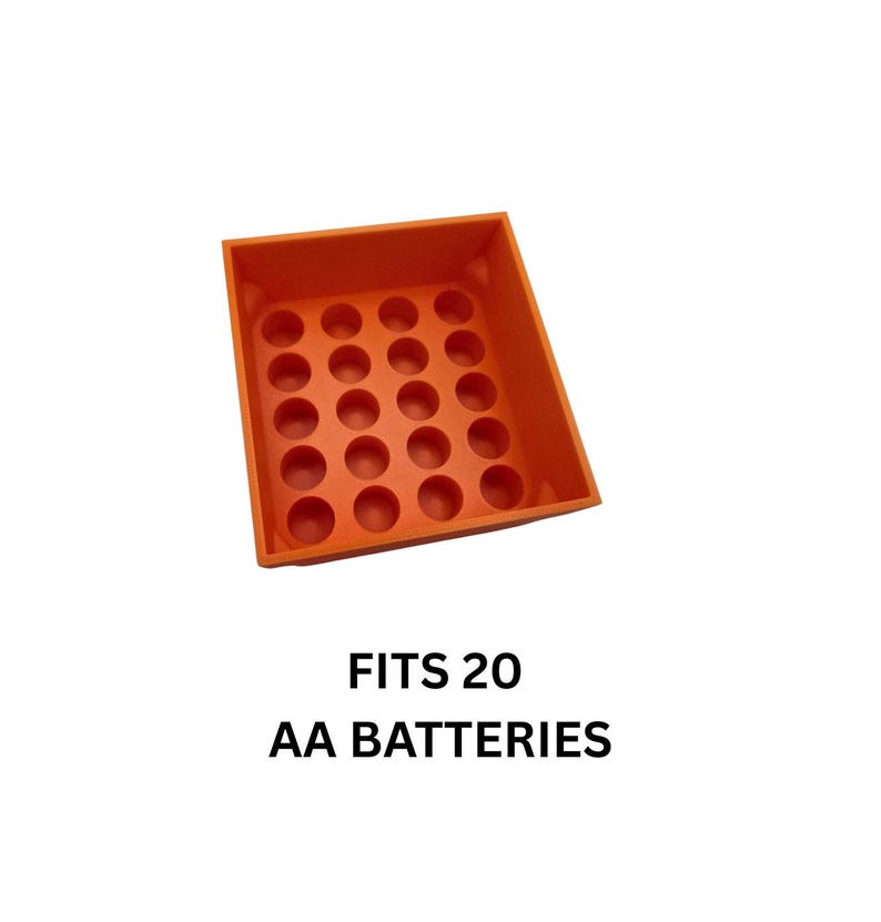 Pode incluir: Um organizador de pilhas de pl&aacute;stico laranja com 20 compartimentos circulares. O texto "FITS 20 AA BATTERIES" est&aacute; impresso abaixo. O organizador foi projetado para armazenar pilhas AA.