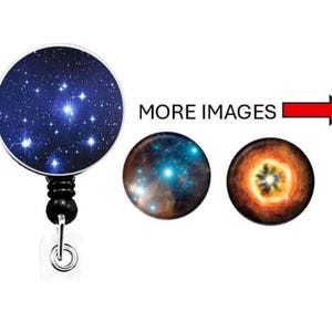 May include: A retractable badge reel with a celestial design. The main reel features a dark blue background with a cluster of bright white stars. The words "MORE IMAGES" are displayed with a red arrow pointing to two additional designs.