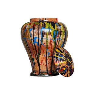 Puede incluir: Un tarro de madera con tapa, ambos pintados con diseños abstractos coloridos en tonos de azul, amarillo, rojo y negro.