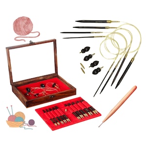 May include: A set of wooden knitting needles in a wooden box with a glass lid. The needles are arranged in a red velvet-lined case. The set also includes a small wooden tool and a ball of yarn.