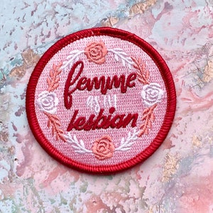 Könnte beinhalten: Ein gestickter Aufnäher in Rot und Rosa mit einem Blumendesign und dem Text "femme and lesbian".