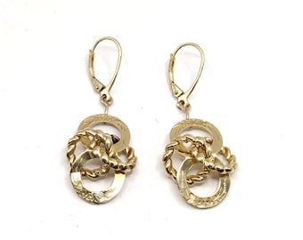 May include: A pair of gold earrings with a twisted rope design and three interlocking circles. The circles have a delicate etched pattern.