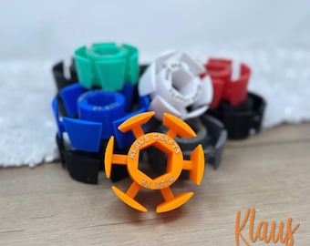 May include: A set of six colorful 3D printed plastic hex nut holders. The holders are designed to fit standard hex nuts and are labeled with the text "Klaus Crafts".