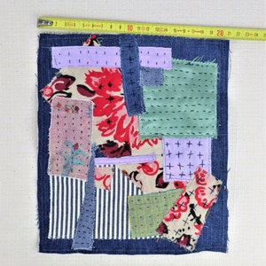 以下が含まれることがあります： デニム、花柄、ストライプなど、さまざまな生地で作られたパッチワークキルト。キルトはさまざまな色とパターンで縫い合わされ、ユニークで質感のあるデザインになっています。