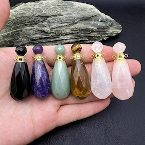 Puede incluir: Siete botellas colgantes de piedras preciosas con tapas doradas. Las botellas son facetadas y vienen en negro, morado, verde, marrón y rosa.