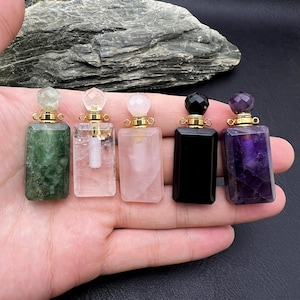 Op de afbeelding: Vijf kristallen flesstoppen met gouden doppen. De stoppen zijn gemaakt van groene aventurijn, helder kwarts, rozenkwarts, zwarte onyx en amethist.