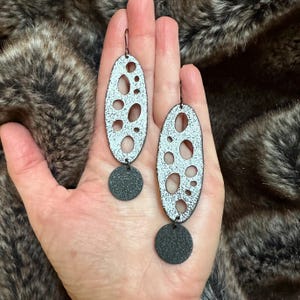 Círculos de vida. Pendientes colgantes divertidos y originales. Pendientes únicos en blanco y negro con textura.