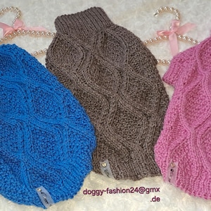 May include: Three knitted dog sweaters in blue, brown, and pink with a cable knit pattern. The sweaters have a turtleneck style.