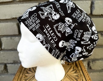 May include: Black and white skull and skeleton print fabric scrub hat with the text "But First... Coffee", "Life is too short for bad coffee", "Rise & Grind", and "Coffee or Die".