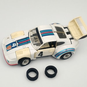 May include: White toy car with blue and red racing stripes, a rear spoiler, and the number "4" on the side. The car has black tires and a clear windshield.