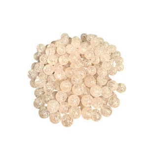 May include: A pile of clear, round, crystal beads with a textured surface.