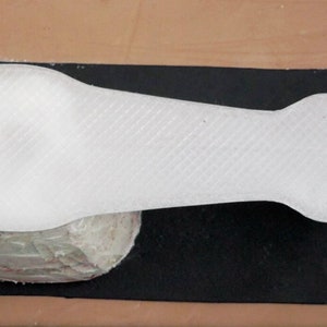 May include: White plastic 3D printed model of a hand with a textured surface.