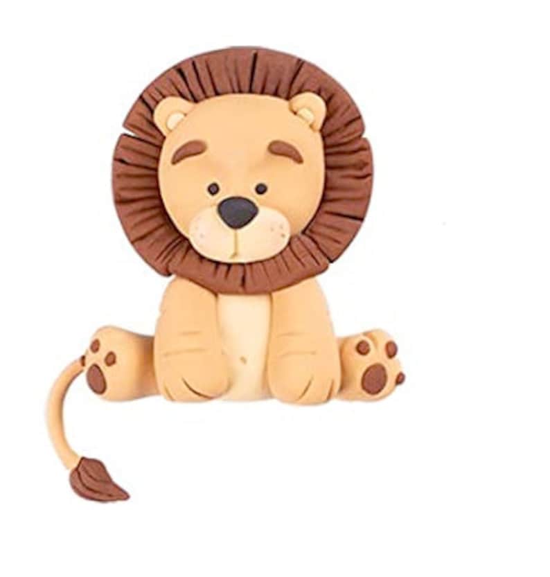 Puede incluir: Una figurita de le&oacute;n marr&oacute;n y beige con una melena marr&oacute;n. El le&oacute;n est&aacute; sentado con las piernas cruzadas y tiene una cola que se enrosca detr&aacute;s de &eacute;l.