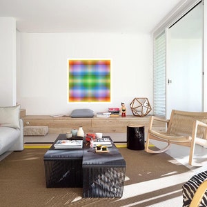 May include: A living room with a light brown rug, a gray couch, a black coffee table, a rocking chair, and a colorful abstract painting on the wall.