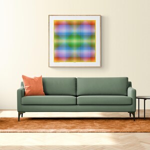 May include: A green sofa with a burnt orange throw pillow sits in front of a framed abstract art print with a yellow, green, blue, and purple color scheme. The sofa is in front of a brown rug on a wood floor.