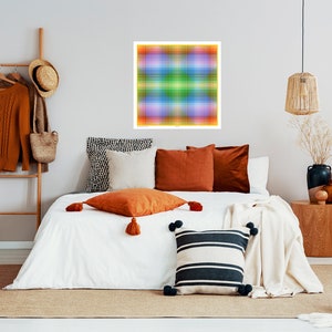 May include: A bedroom interior with a white bed, a brown rug, and a colorful abstract artwork hanging on the wall. The bed is made with white bedding and has several pillows in various colors and patterns. There is a wooden side table with a vase of dried flowers and a brown wicker basket on the floor.