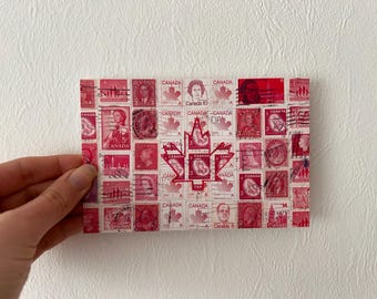 May include: A rectangular collage of vintage Canadian postage stamps in shades of red and pink. The stamps feature portraits, maple leaves, and the word "Canada." A large maple leaf design is in the center. The collage is held by a hand.